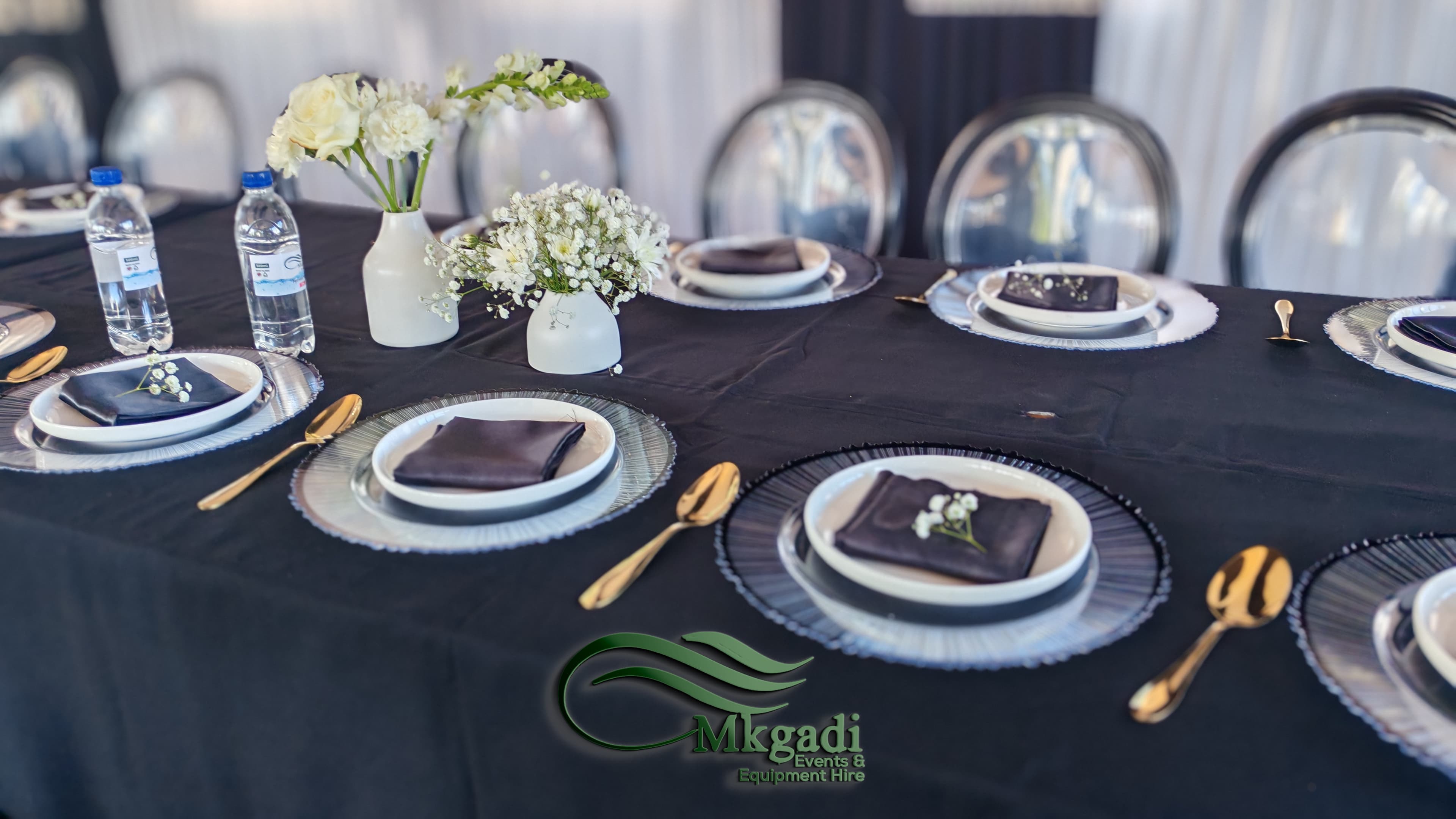 Full marquee tent setup with white draped ceiling, round banquet tables and coordinated chair covers for a formal event